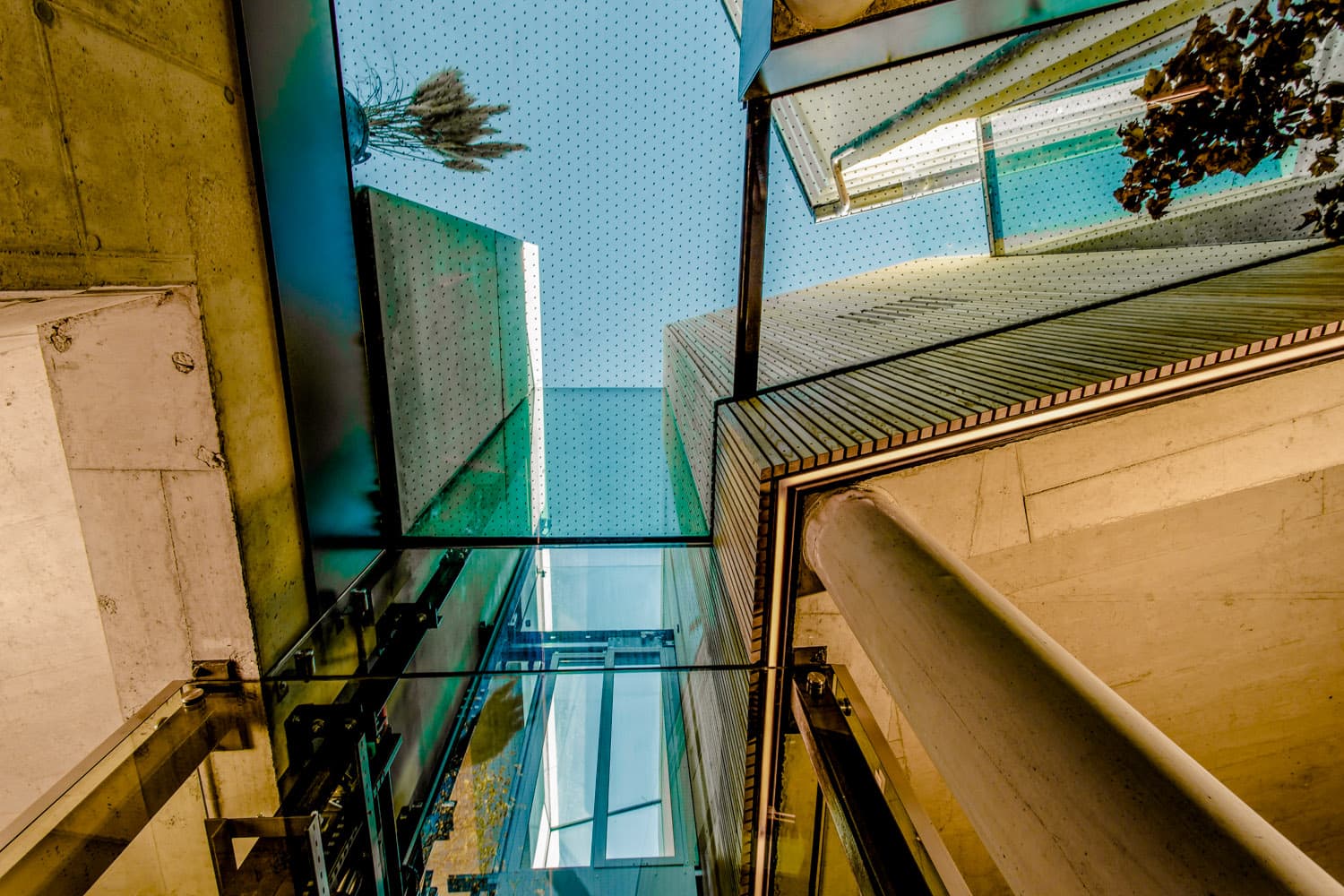 Blick nach oben durch einen verglasten Lichthof mit Metallkonstruktion